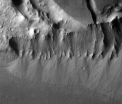 Streams flowing over the edge of Kasei Valles (top) washed down sediments that collected as alluvial fans at the foot of the slope. (NASA/JPL-Caltech/Arizona State University)