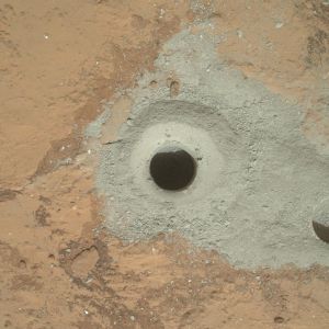 At the center of this image from NASA's Curiosity rover is the hole in a rock called "John Klein" where the rover conducted its first sample drilling on Mars. The drilling took place on Feb. 8, 2013, or Sol 182, Curiosity's 182nd Martian day of operations. Several preparatory activities with the drill preceded this operation, including a test that produced the shallower hole on the right two days earlier, but the deeper hole resulted from the first use of the drill for rock sample collection. Image credit: 